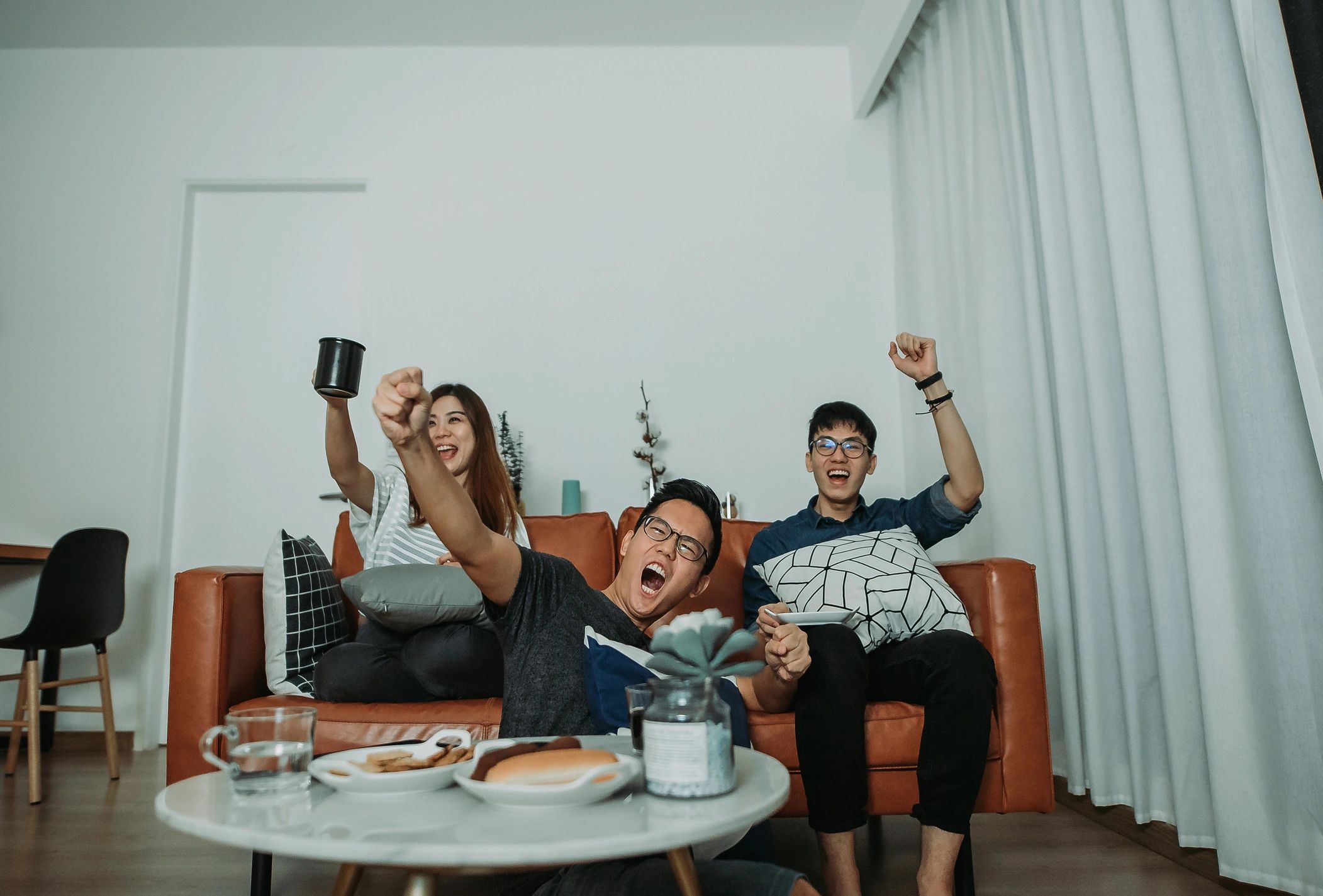 Aficionados viendo un partido en casa con buen ambiente