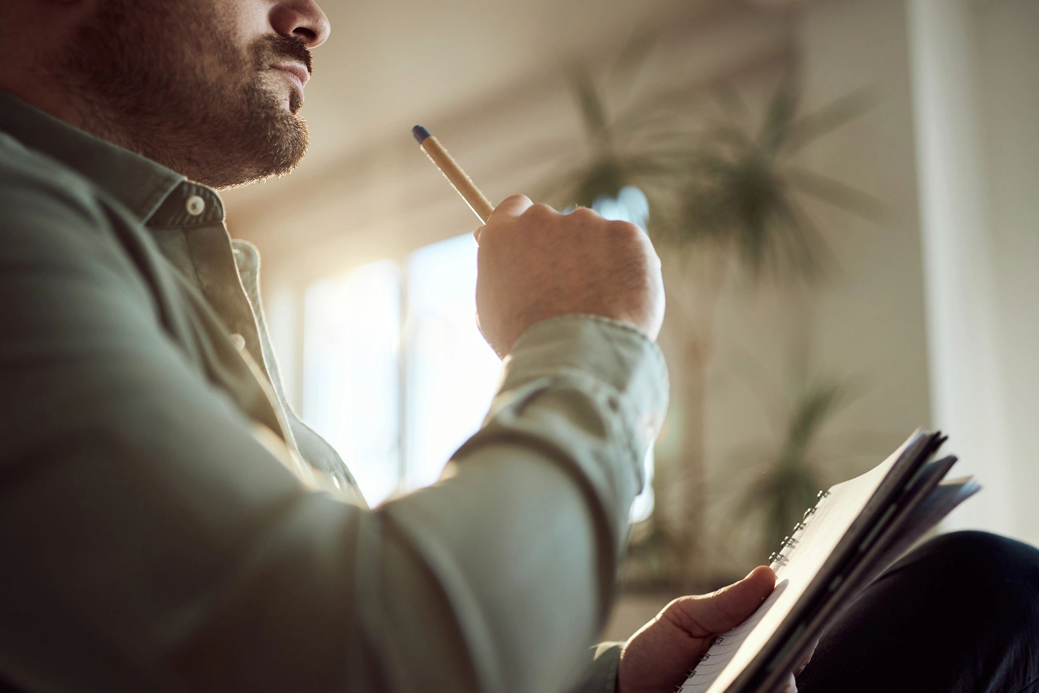 Persona escribiendo y reflexionando en un cuaderno