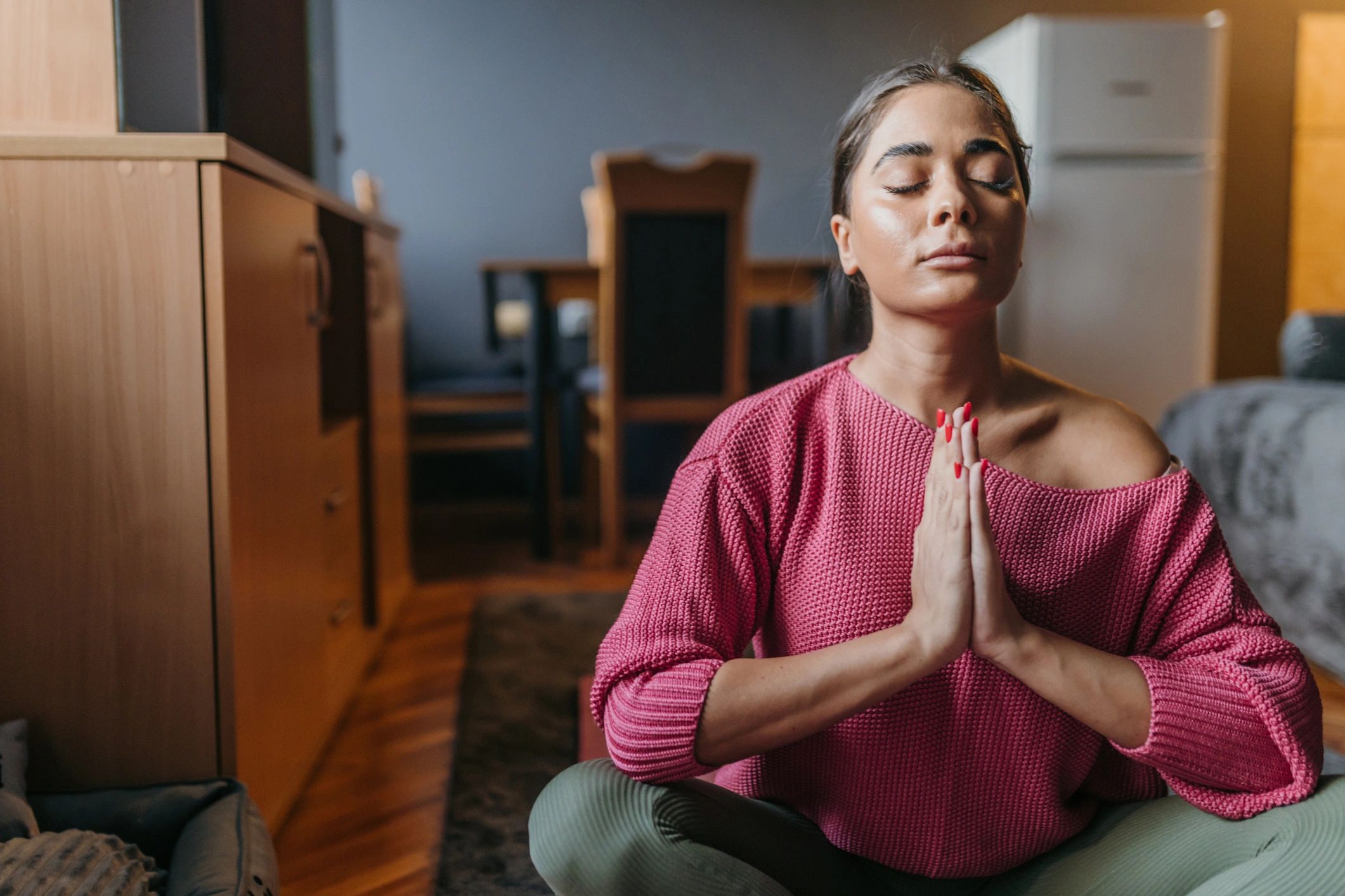 Persona meditando en casa para entrenar la calma y el autocontrol emocional